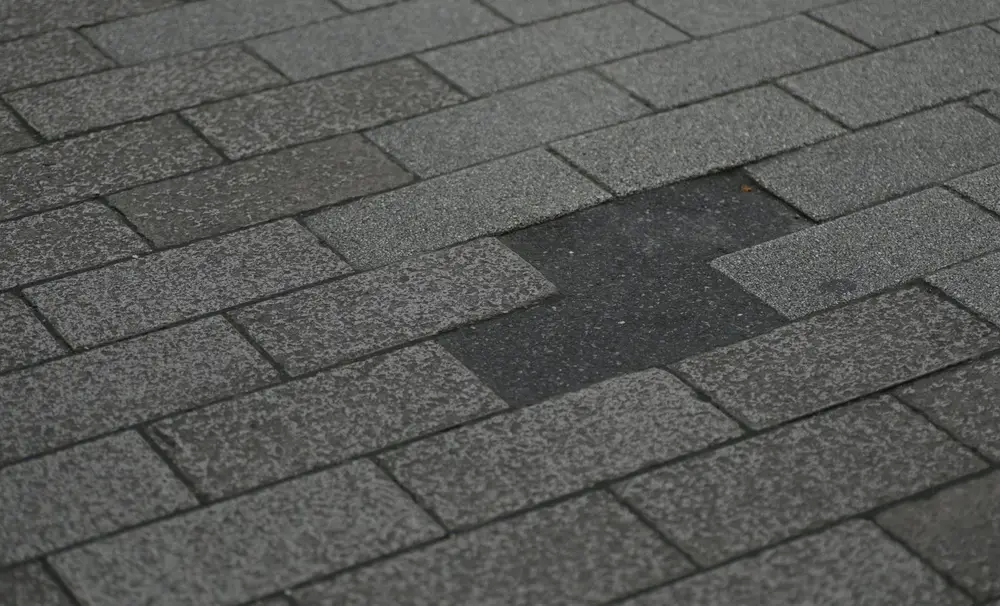 Close view of the textured surface and overlapping edges of asphalt shingles.