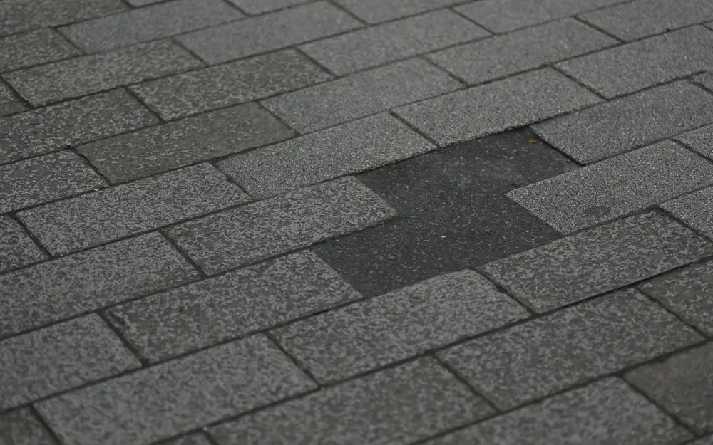 Close view of the textured surface and overlapping edges of asphalt shingles.